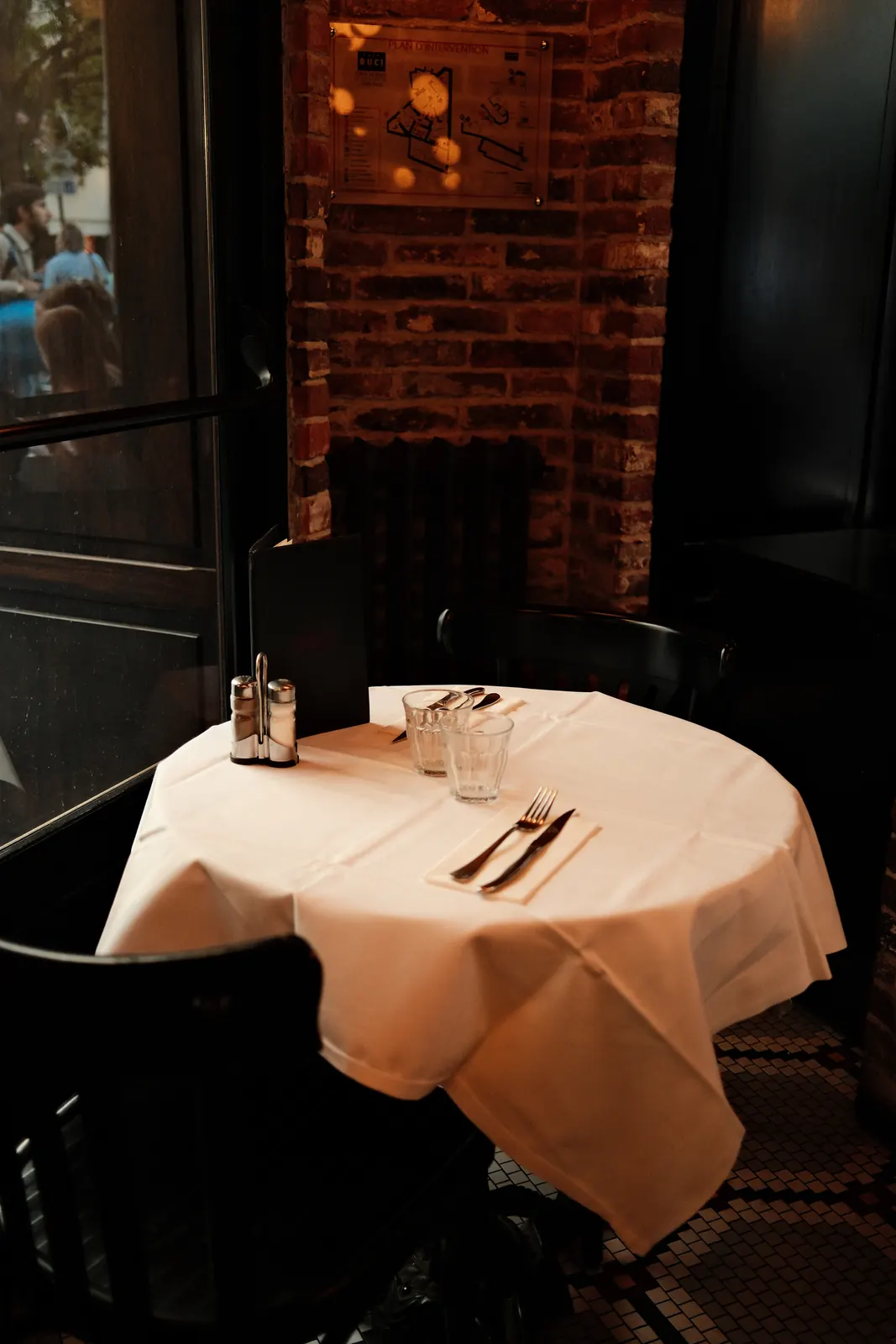 White-clothed table by the brick wall